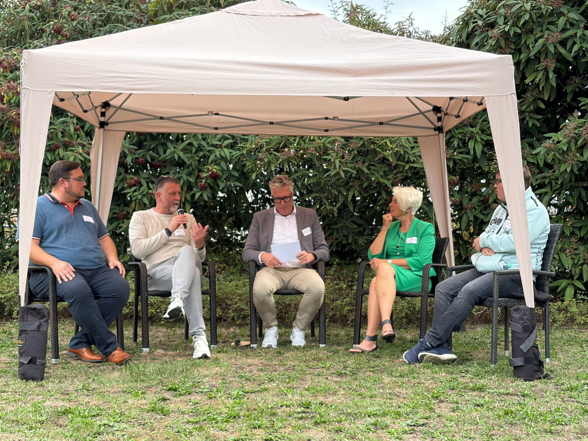Das Foto zeigt fünf Personen, die unter einem Pavillon sitzen, im Gespräch. 
&copy; kreuznacher diakonie gGmbH